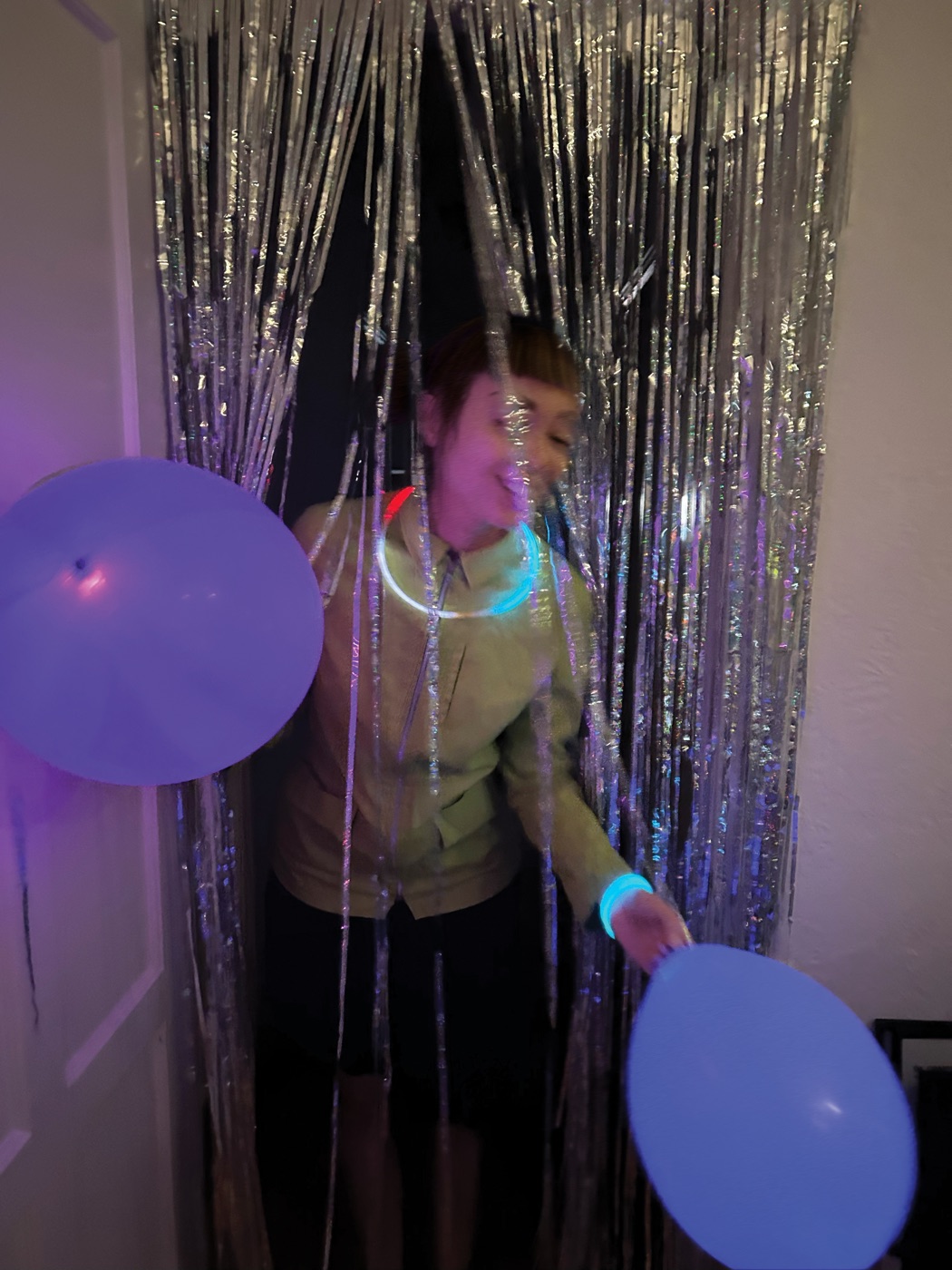 Miquela through the tinsel curtain at the glow party